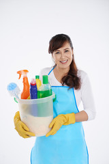 Smiling Asian housewife with basket of cleaning supplies