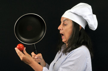 Cuisinière avec une poêle et une tomate
