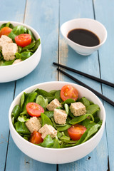 Vegan tofu salad in bowl on blue wood
