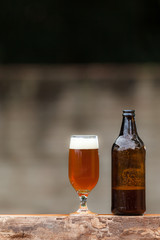 Glass of beer and bottle on wood table