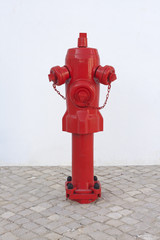 An old red fire hydrant in portuguese sidwalk