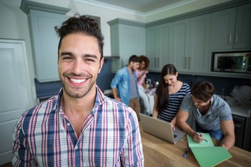Fototapeta premium Portrait of cheerful man with friends in background