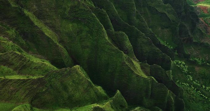 Aerial view flying over jungle mountain peaks revealing tropical coastline, Na Pali coast Kauai