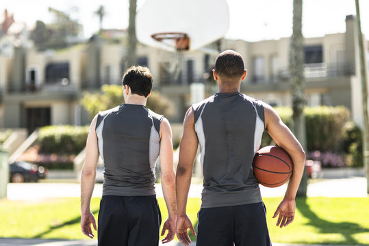 Rear view of two basketball players outdoors