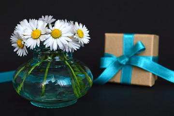 Gift and flowers on dark background