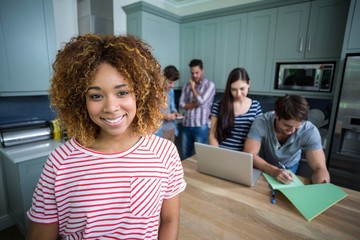 Portrait of smiling young woman with friends in background