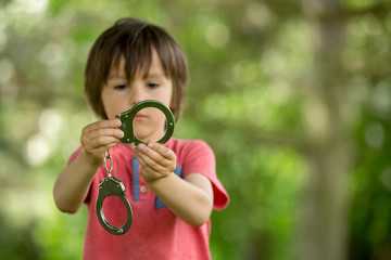 Cute little boy with the hand cuffs on his hands