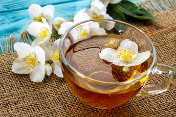 Obraz na płótnie Canvas jasmine tea and jasmine flowers on wooden background