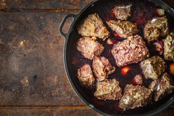 Boeuf Bourguignon in the pan on the metal background top view