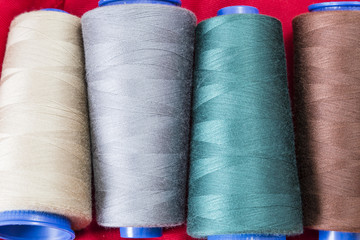 Several spools of thread of different colors and sizes
