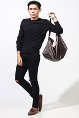 asian man posing with leather bag