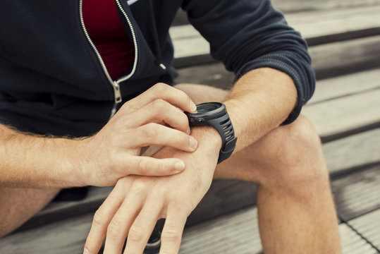 Urban jogger checking at heart rate monitor smartwatch 