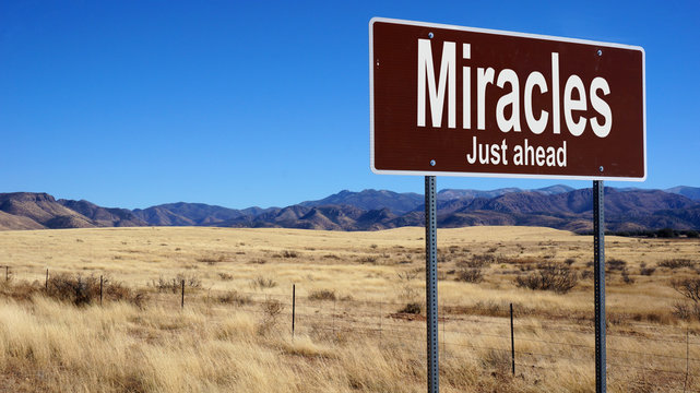 Miracles Just Ahead brown road sign