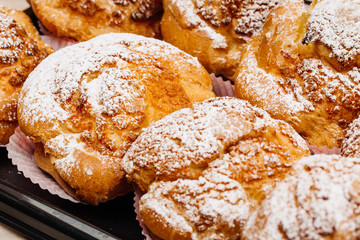 .Cream puffs filled with pastry cream and sprinkled with powdere