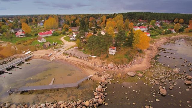 The village of Kasmu in Estonia in an aerial shot. Seen the wooden houses near the rocky shore and the boats on dock