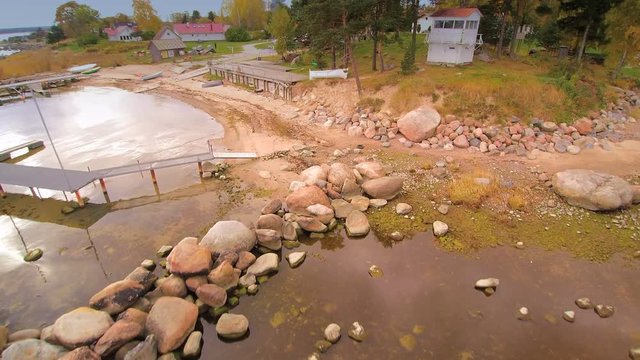 The rocky shore of the sea in Kasmu Estonia where small boats are docking on the shore.