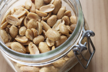 Open canning jar with fried salty peanuts. Overhead view