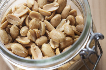Open canning jar with fried salty peanuts. Overhead view
