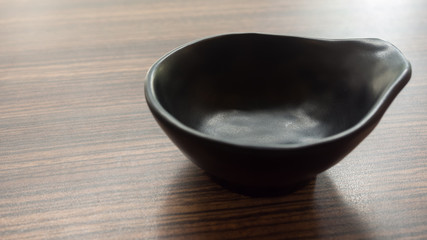 black porcelain bowl empty on wooden table