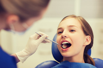 female dentist checking patient girl teeth