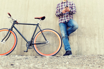 close up of hipster man with smartphone and bike