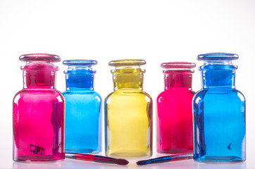 Five colored little bottles and two brushes.