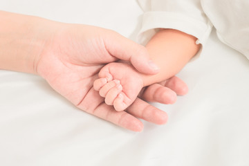 selective focus hand the sleeping baby in the hand of mother clo