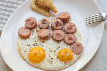 Hearty breakfast of eggs, sausage and toasts.