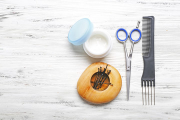 Hairdresser set with various accessories on wooden background