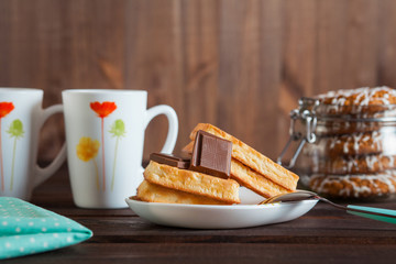 Belgium waffles with chocolate on a wooden table.