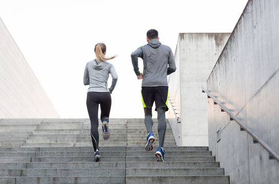 couple running upstairs on city stairs