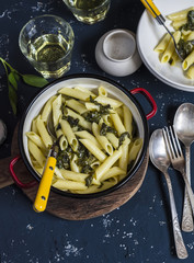 Pasta with spinach, blue cheese cream sauce on dark stone background