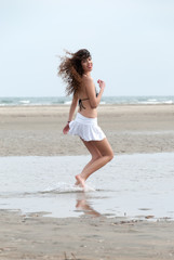 Fototapeta na wymiar Slim woman walking and plying at sea
