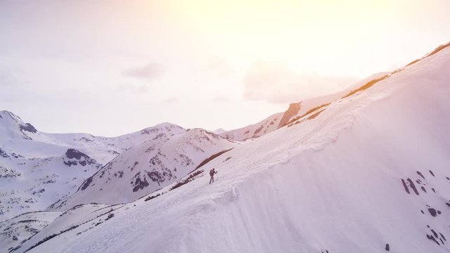 Climber Man Walking Up Mountain At Sunset Reaching The Top Success Fly Over Aerial Drone Footage