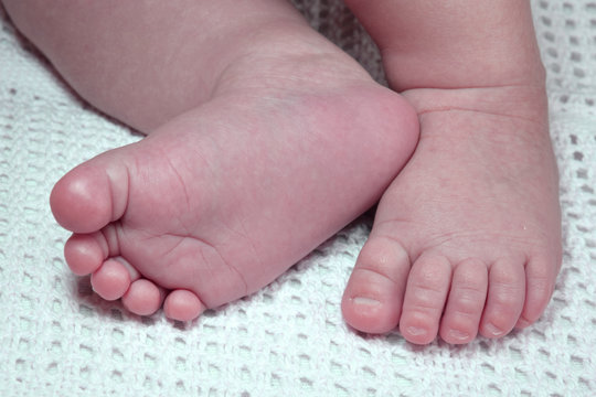 Newborn child cute feet on blanket