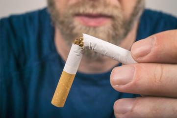 Quit Smoking - Man holding a broken cigarette