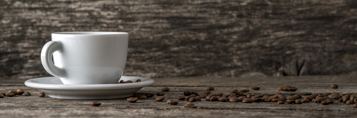 Coffee cup on a plate on the left side of an image and scattered