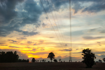 Silhouette high voltage electricity pylon at time sunset.