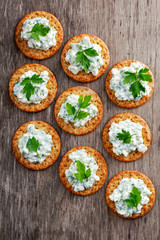 Bisquit cracker appetizers with cottage chees and parsley topping