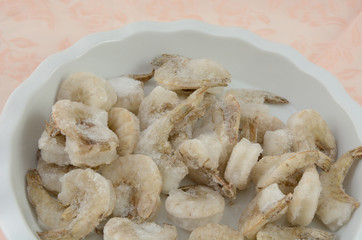 Close up of Frozen shrimp thawing in white bowl