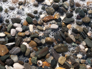 Stones with sea foam background from above