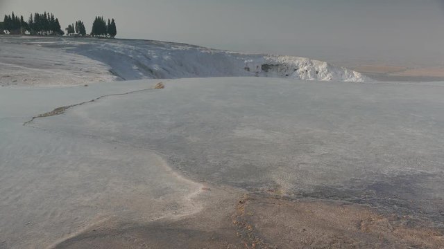 Natural sightseeing of flowing mineral water over white terraces in Pamukkale, Turkey. 4k