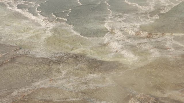Closeup of hot water flowing over calcium travertines with steam in Pamukkale, Turkey. 4k