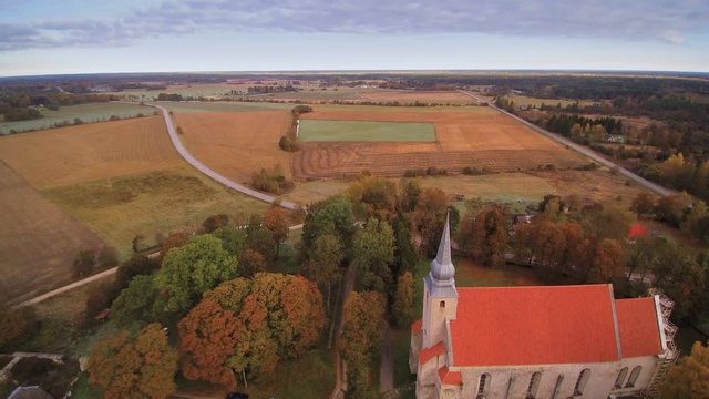 The aerial shot of Kaarma parish in Saarema. Seen the big open green fields and the trees on the forest
