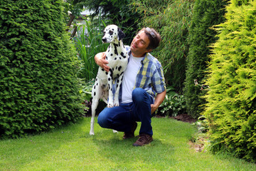 Hund steht auf Bein von Mann im Garten