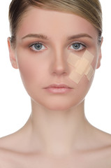 Fototapeta premium Young woman with medical plaster on her face