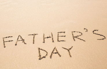 Father's Day hand written in the sandy beach