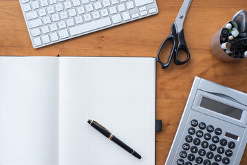 Desk with keyboard, notebook, fountain pen and calculator