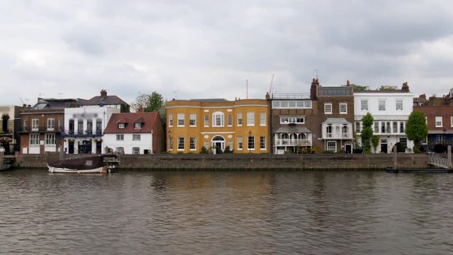 Dolly view of a typical English riverside village in West London