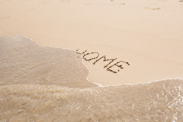 word home written in sand on beach